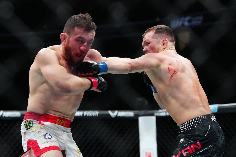 Merab Dvalishvili (red gloves) fights Petr Yan (blue gloves) during UFC 323 at T-Mobile Arena.