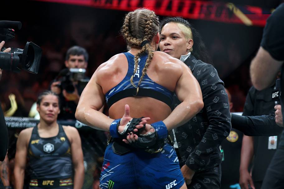 Kayla Harrison (blue gloves) talks to Amanda Nunes after defeating Julianna Pena (not pictured) in a bantamweight title bout