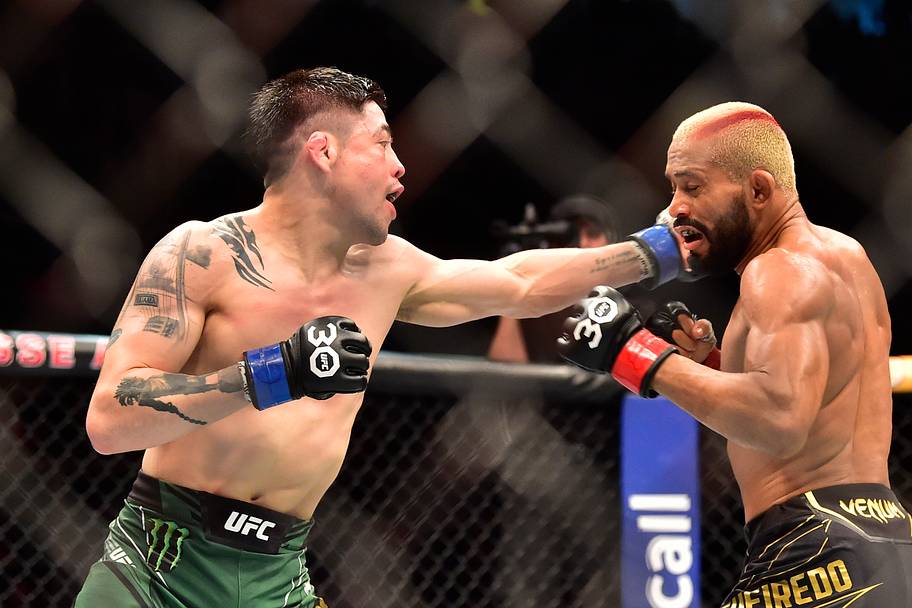 Deiveson Figueiredo (red gloves) fights Brandon Moreno (blue gloves) during UFC 283 at Jeunesse Arena.