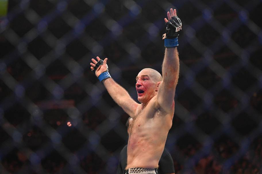 Sean Strickland (blue gloves) celebrates after defeating Khamzat Chimaev (red gloves) during UFC 328 at Prudential Center.
