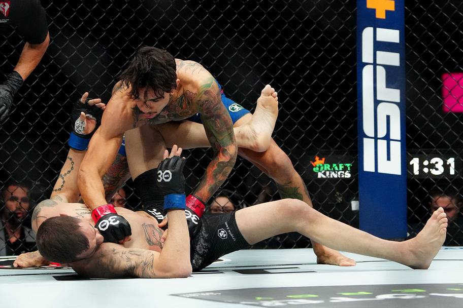 Andre Fili (red gloves) fights Lucas Almeida (blue gloves) during UFC 296 at T-Mobile Arena.