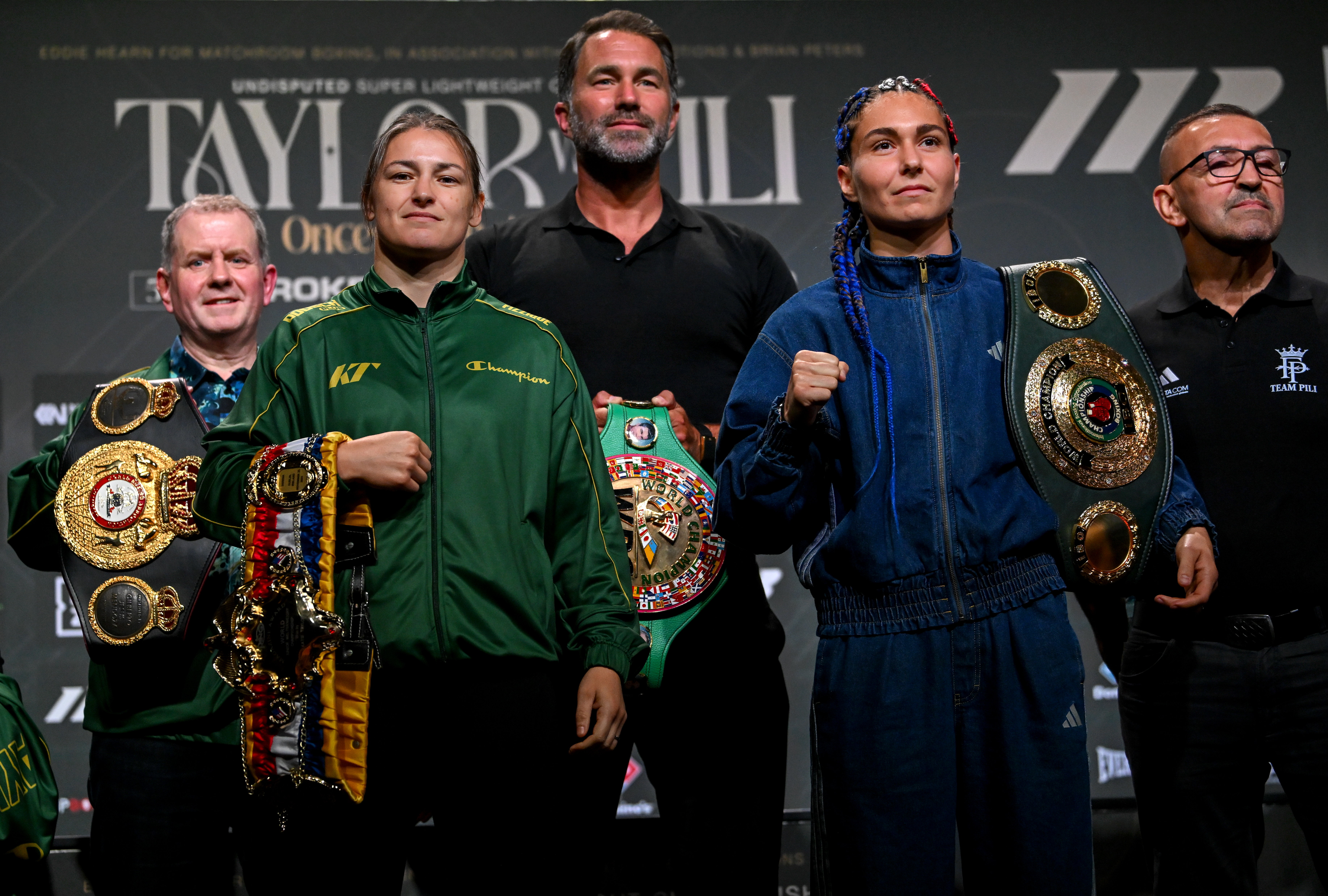 Dublin , Ireland - 1 September 2026; Katie Taylor and Flora Pili, right, square-off in the company of Brian Peters, Katie Taylor's manager, left, and Matchroom Boxing promoter Eddie Hearn, centre, during a press conference, held at The Helix in DCU, Dublin, ahead of their undisputed super lightweight championship fight on September 5th at Croke Park in Dublin. (Photo By Stephen McCarthy/Sportsfile via Getty Images)