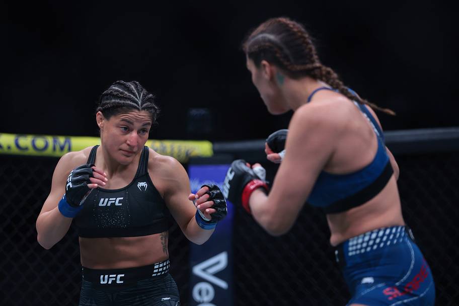 Tatiana Suarez (red gloves) fights Loopy Godinez (blue gloves) during UFC 327 at Kaseya Center.