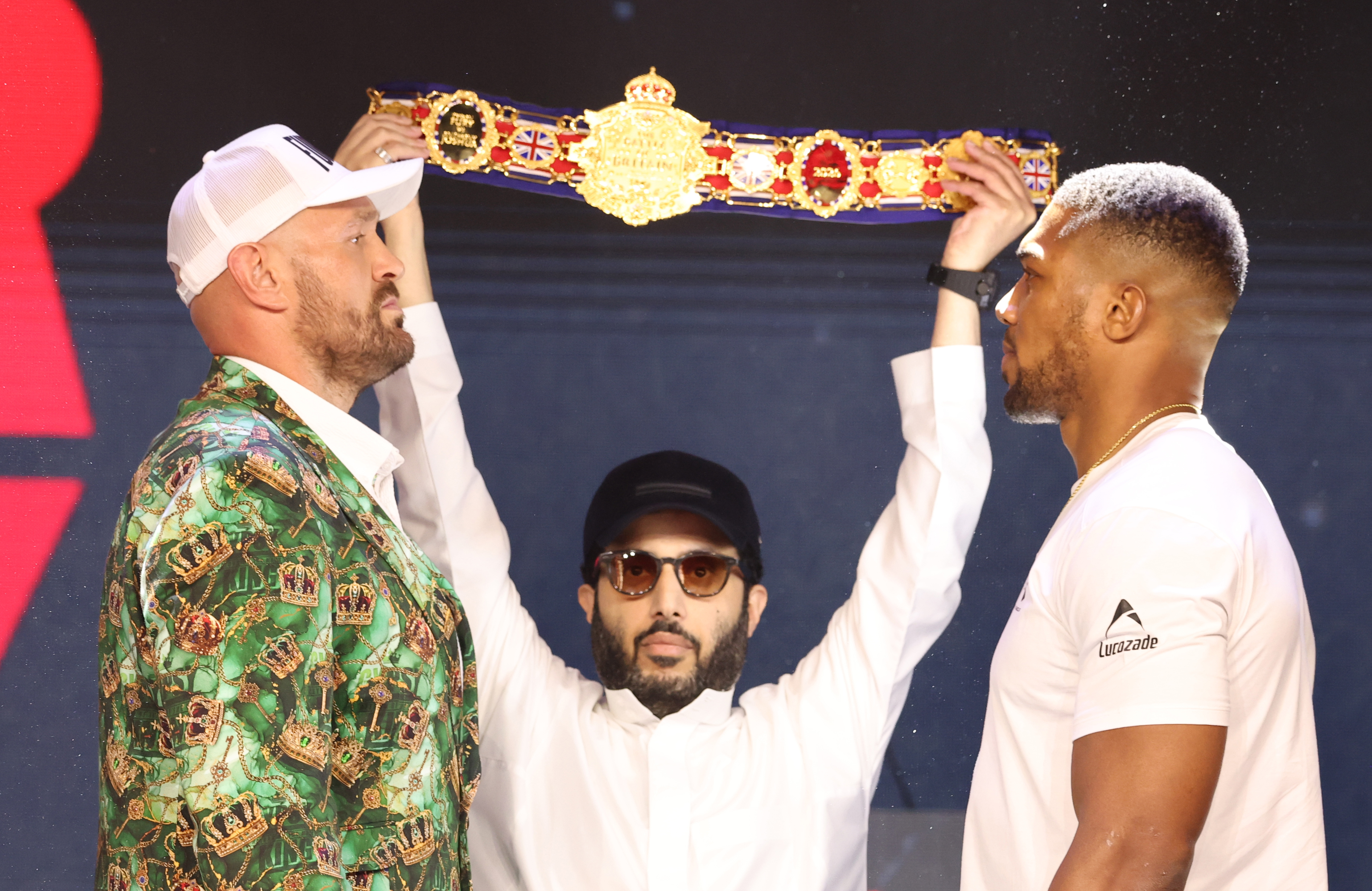 HAMMERSMITH, ENGLAND - SEPTEMBER 30: Tyson Fury (left in camouflage) and Anthony Joshua (right in white) with HE Turki Alalshikh in centre holding up the belt during the announcement for the upcoming Tyson Fury vs. Anthony Joshua fight at The British Airways Arc on September 30, 2026 in Hammersmith, England. The fight will stream live on Netflix on 11th December. (Photo by Mark Robinson/Getty Images)