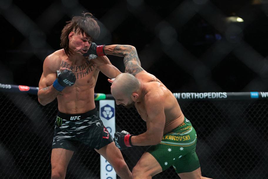 Alexander Volkanovski (red gloves) fights against Diego Lopes (blue gloves) during UFC 314 at Kaseya Center.