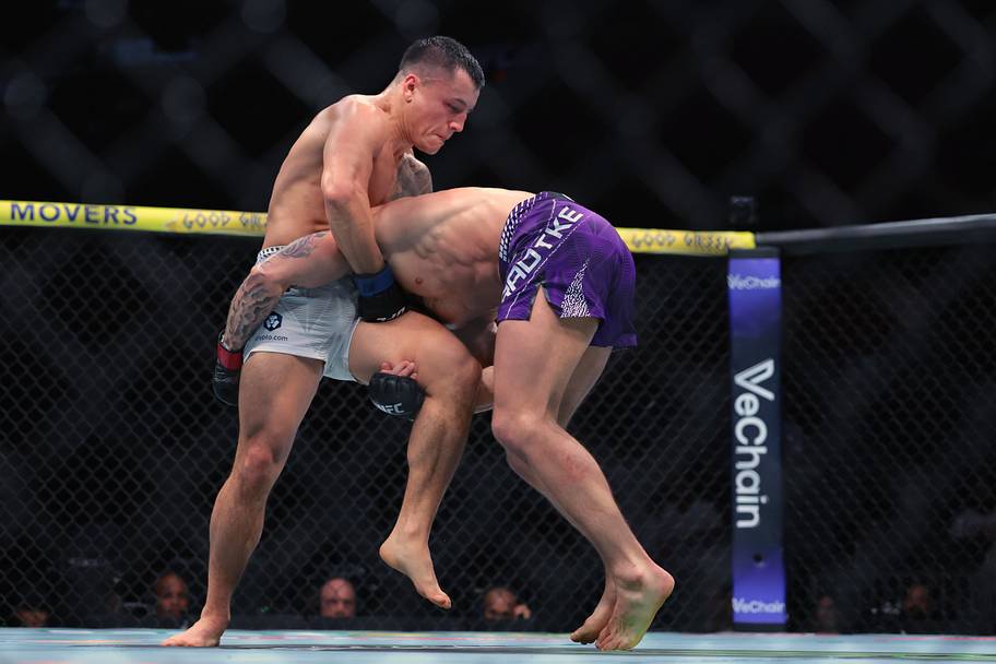 Charles Radtke (red gloves) fights Francisco Prado (blue gloves) during UFC 327 at Kaseya Center.