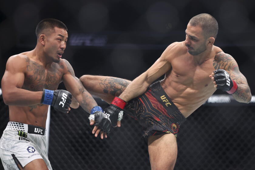 Alexandre Pantoja kicks Joshua Van during a flyweight title fight at T-Mobile Arena on Dec. 6 in Las Vegas.