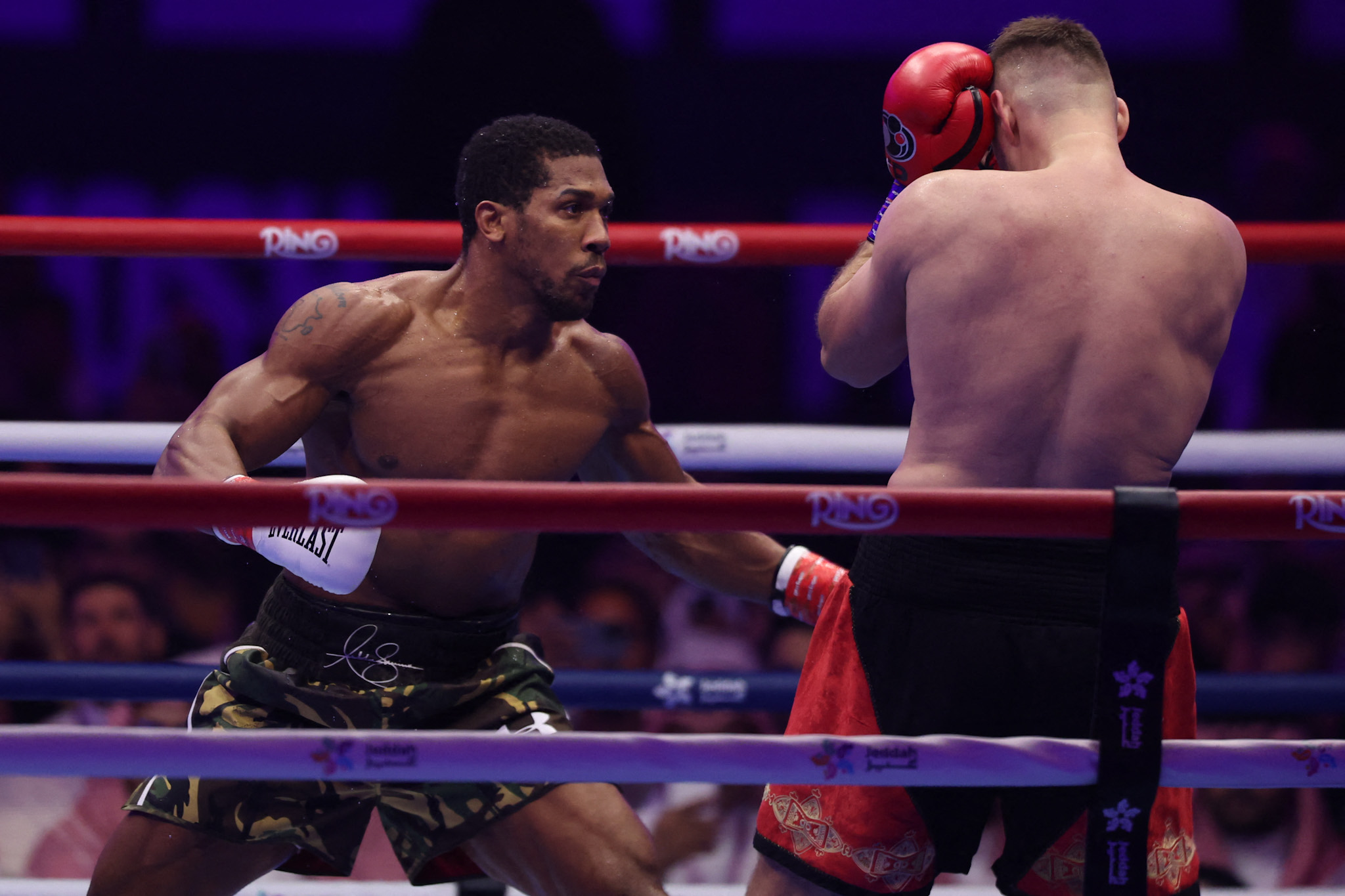 Britain's Anthony Joshua (L) and Albania's Kristian Prenga trade blows during their heavyweight boxing fight at the Jeddah Superdome in Jeddah on July 26, 2026. Two-time heavyweight world champion Anthony Joshua survived two early knockdowns on the way to a second-round knockout of Kristian Prenga on July 26, his triumphant ring return paving the way for a blockbuster all-British bout with Tyson Fury. (Photo by AFP via Getty Images)