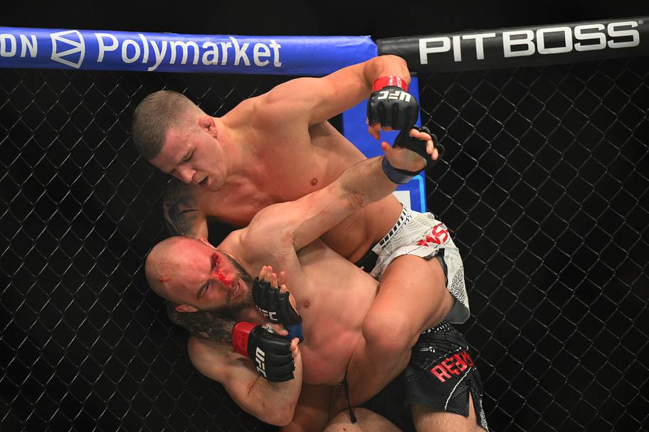 Grant Dawson (red gloves) fights Mateusz Rebecki (blue gloves) during UFC 328 at Prudential Center.