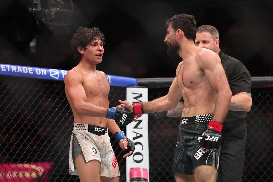 Farid Basharat (red gloves) shakes hands with John Garza (blue gloves) after a bantamweight bout during UFC 329 at T-Mobile A