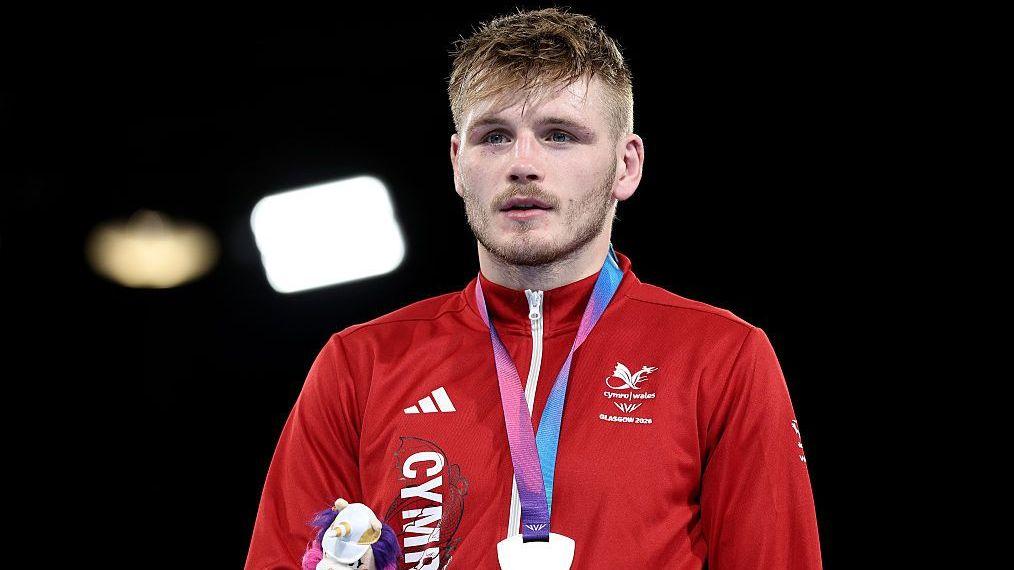 Connor Williams in the red of Team Wales wearing a silver medal