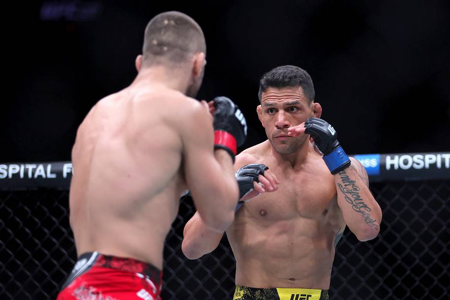 Rafael Dos Anjos (blue gloves) fights Mateusz Gamrot (red gloves) during UFC 299 at Kaseya Center.