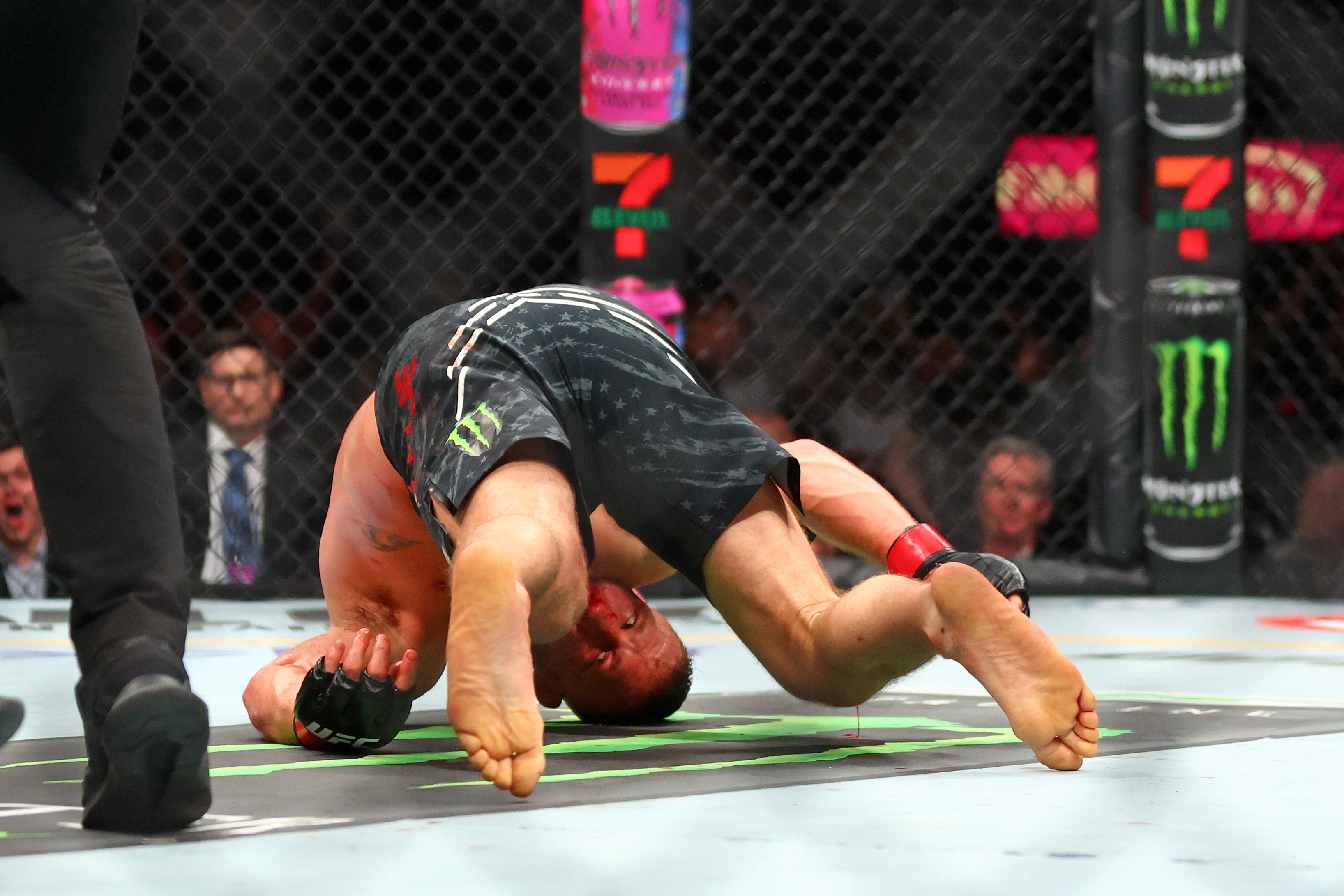 Apr 13, 2024; Las Vegas, Nevada, USA; Justin Gaethje (red gloves) falls to the mat while fighting Max Holloway (blue gloves) during UFC 300 at T-Mobile Arena.