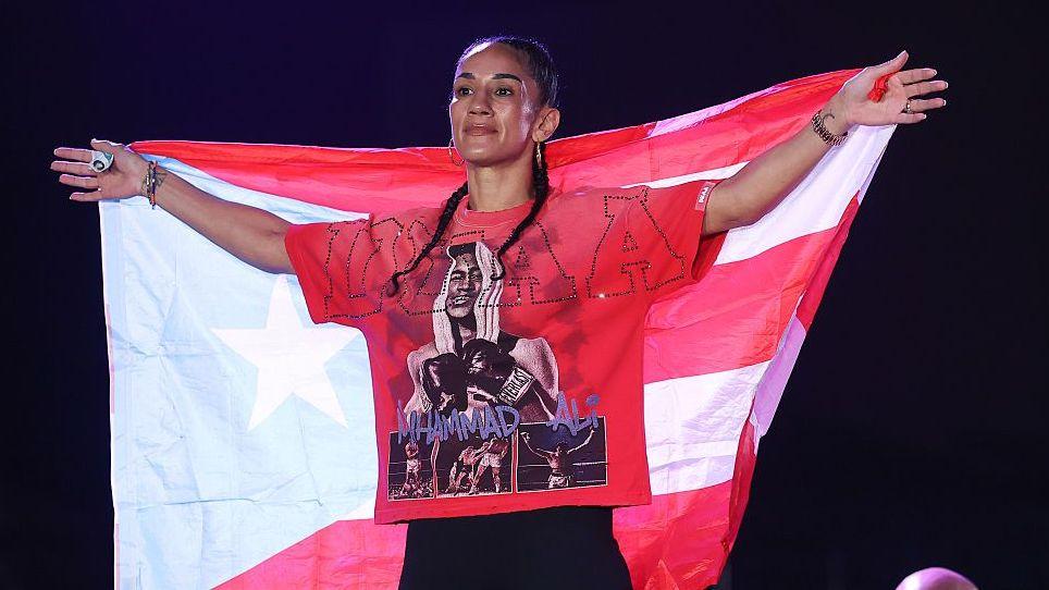 Amanda Serrano poses on the scale at a weigh-in