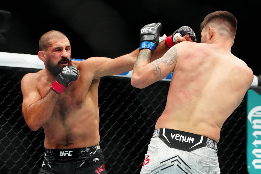 Court McGee (red gloves) fights Tim Means (blue gloves) during UFC 307 at Delta Center.