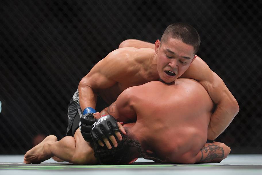 Asu Almabayev (blue gloves) fights CJ Vergara (red gloves) during UFC 299 at Kaseya Center.