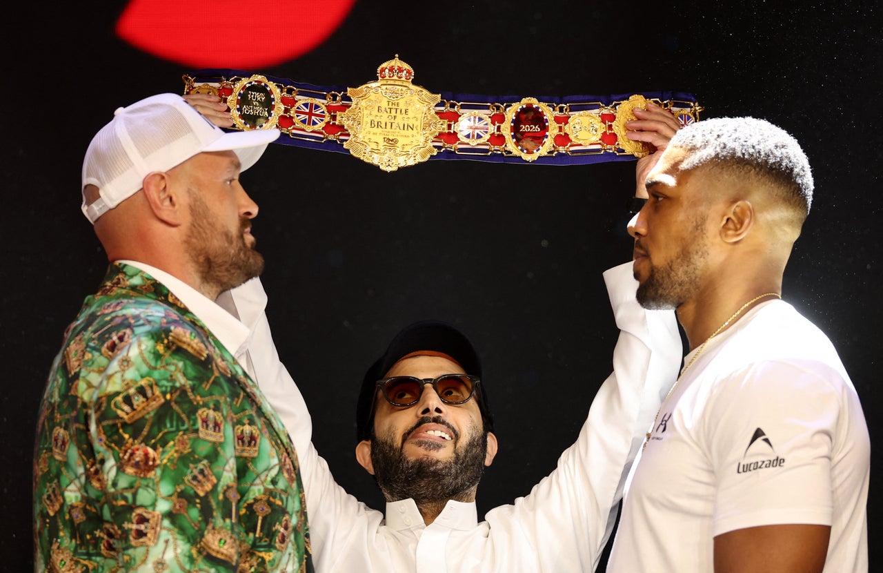 Turki Alalshikh (centre) holds up the belt during Anthony Joshua (right) and Tyson Fury's face off (Reuters)