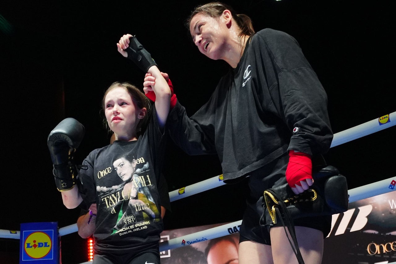 Katie Taylor with a young fan Clodagh Keating, aged 10, during an open workout (Brian Lawless/PA)