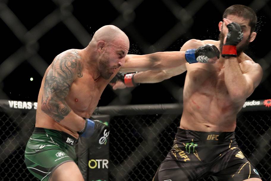 Islam Makhachev (red gloves) fights Alexander Volkanovski (blue gloves) during UFC 284 at RAC Arena.